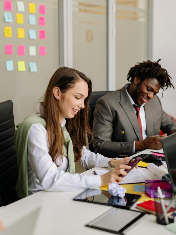 Deux collègues de travail qui sourient au bureau